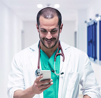 Male doctor checking his schedule on a smartphone.