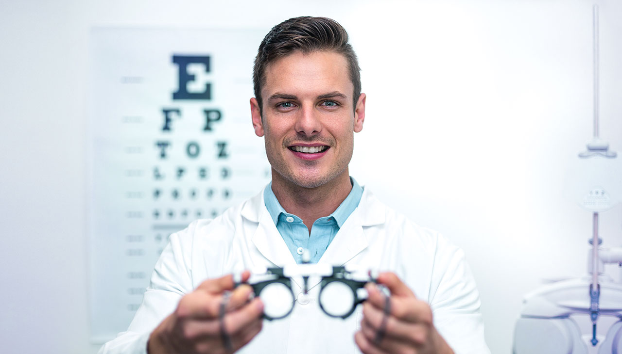 Optičarka med očesnim testom daje očala (mess brille).