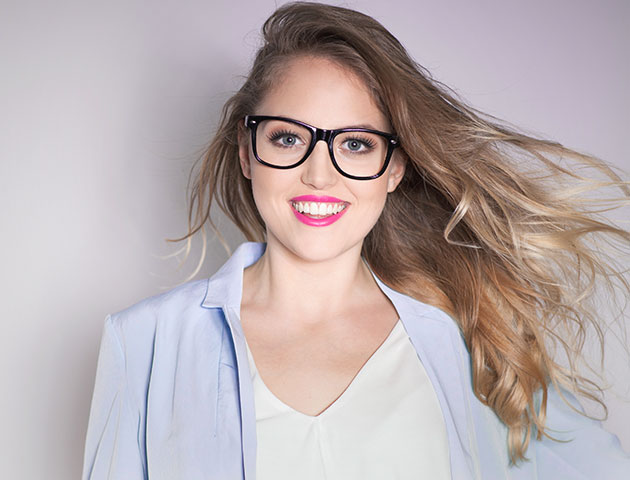 Smiling woman showcasing newly prescribed corrective lenses.