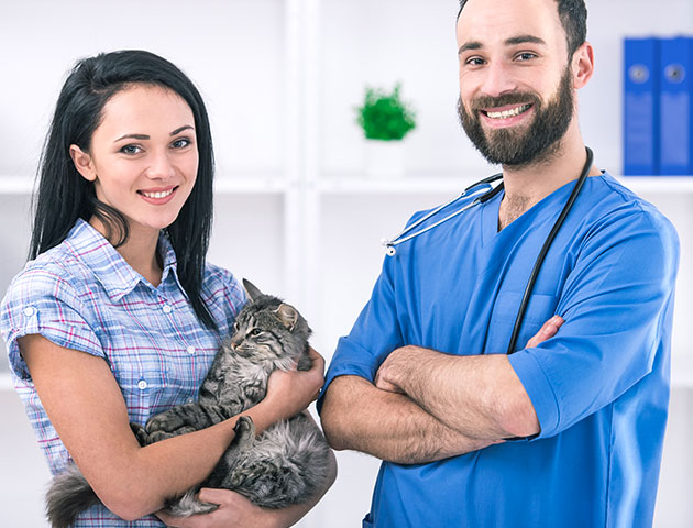 Veterinarian and pet owner posing after a vet appointment.
